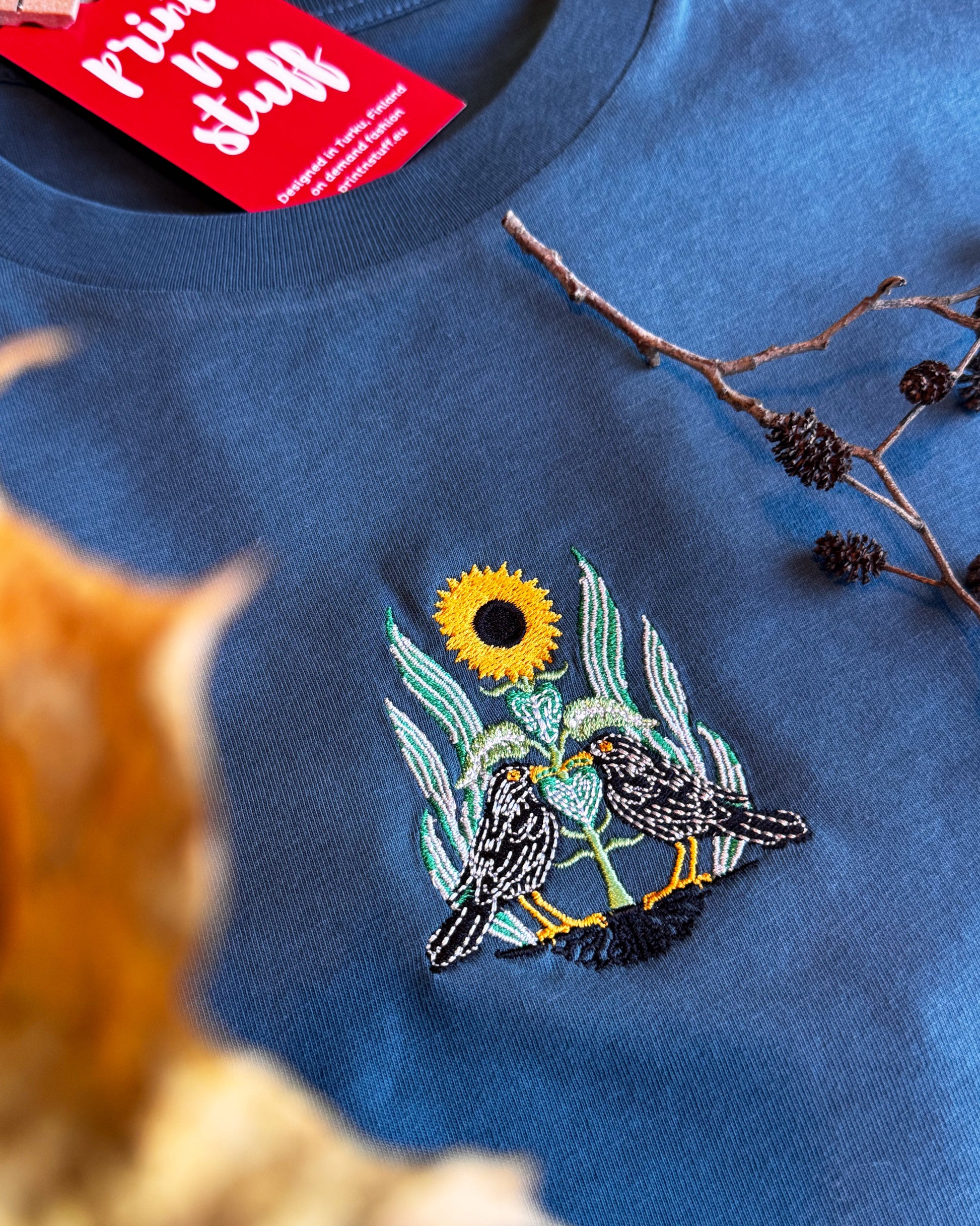 Organic cotton t-shirt with embroidered blackbirds and sunflower—nature-inspired, sustainable, and stylish. Print N Suff turku finland finnish design paita