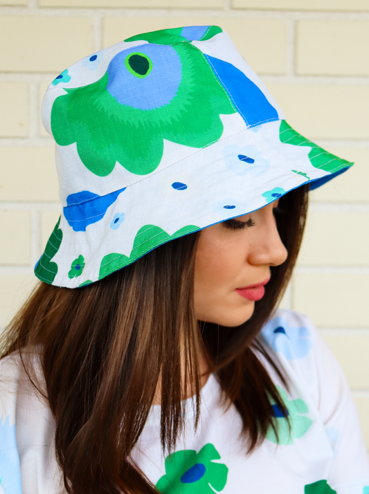 kevat / spring reversible two faced bucket hat inspired by the beauty of Finnish Summers, it is a bucket hat printed all over with a abstract floral pattern intones of green and fresh blue. Designed in Turku Finland by Print N Stuff